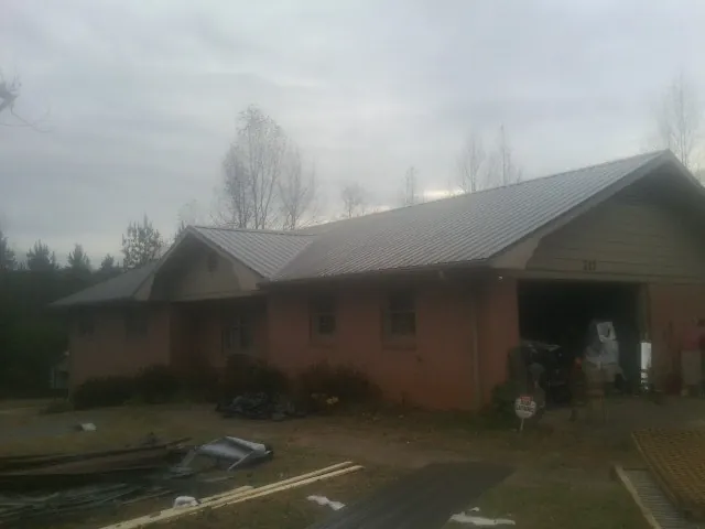 Gray metal roof on a stucco house with an attached garage in Hebron